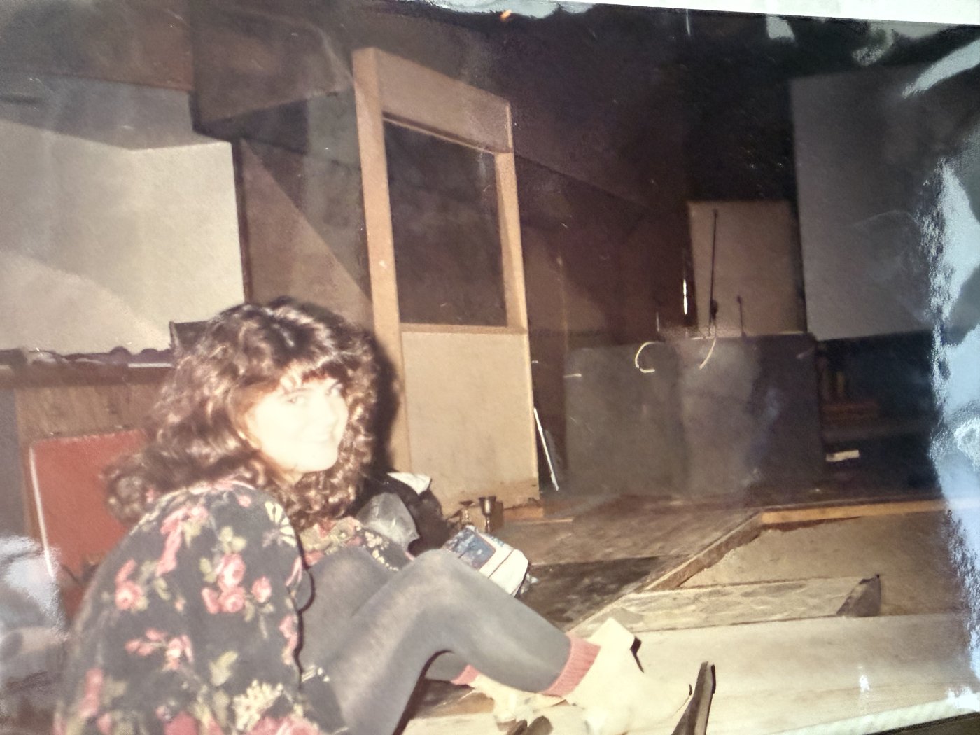 Vintage photograph of Katie Rose sitting on a studio floor, smiling at the camera
